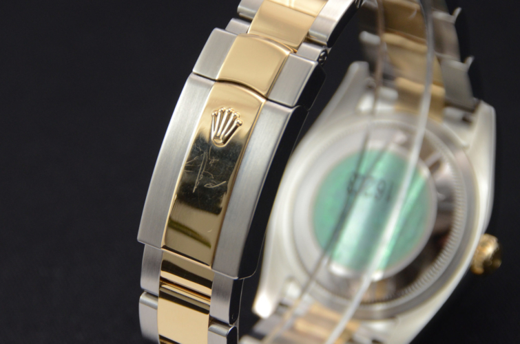Detailed view image of a bimetal grey diamond dot dial Rolex Datejust 116203, with a yellow gold polished finish domed bezel and a stainless steel & yellow gold Oyster bracelet