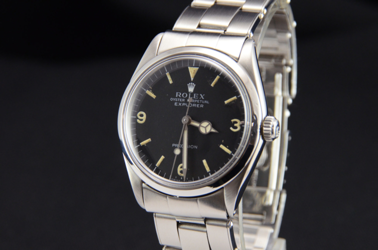 Detailed view image of a vintage stainless steel Rolex Explorer 5500 with a flexible riveted bracelet and aged patina on the dial